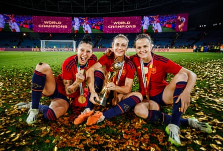 Alexia Putellas holds the Women’s World Cup trophy alongside Jennifer Hermoso and Irene Paredes.