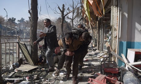 Afghans carry a body after a car bomb in Kabul last month