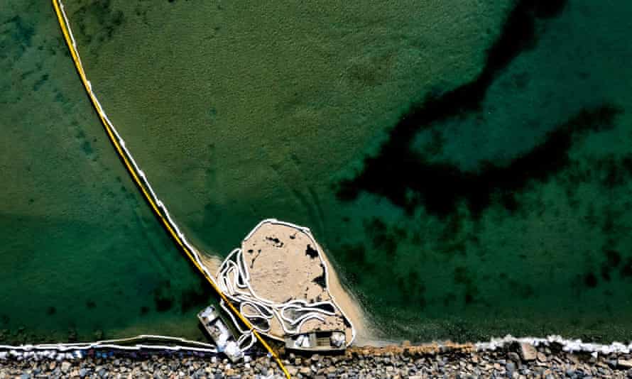 An aerial view of oil booms holding back contaminated water at the Talbert marsh in Huntington Beach, California, on Sunday.