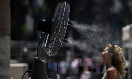 Woman cooling self with fan