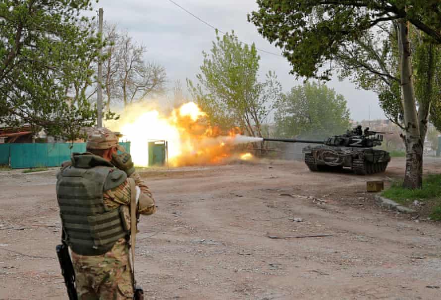 Service members of pro-Russian troops fire from a tank in Mariupol near the Azovstal steel plant.