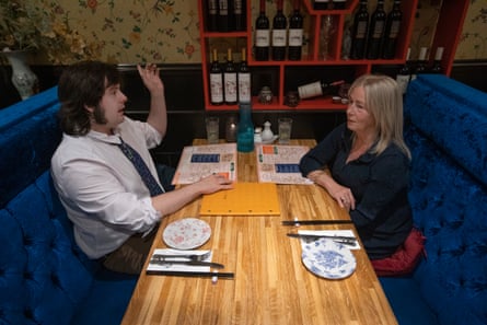 Lucas and Marie-Rose sitting opposite one another chatting at a restaurant table