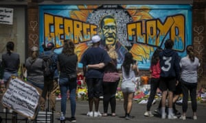 Mourners at a mural of George Floyd, close to the spot where he died in Minneapolis.