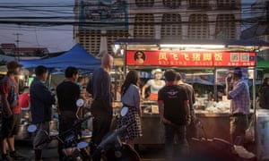 Nightime shot of customers lining up next to the Cowgirl’s street food cart in Chiang Mai, Thailand.