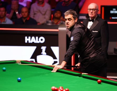 Ronnie O’Sullivan at the snooker table, pulling a face as he prepares to take a shot