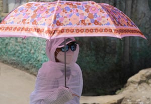 A schoolgirl shelters under an umbrella in Prayagraj, India