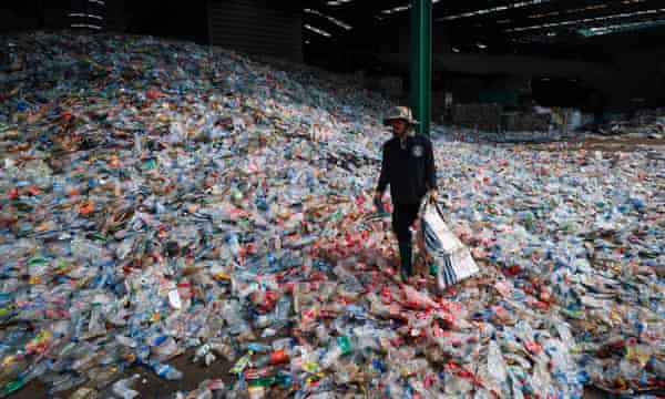 A worker sorts through plastic bottles at the recycling plant near Bangkok in Thailand.