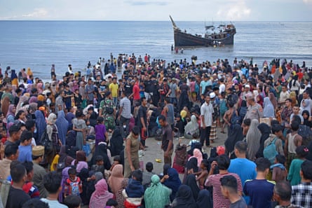 Local residents and newly arrived ethnic Rohingya gather on the a beach in Aceh.
