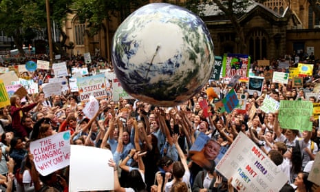 An inflatable planet earth is bounced around the crowd during a climate rally in Sydney