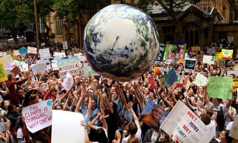 Climate protesters hold up a giant inflatable ball painted to look like the planet at a rally in Sydney