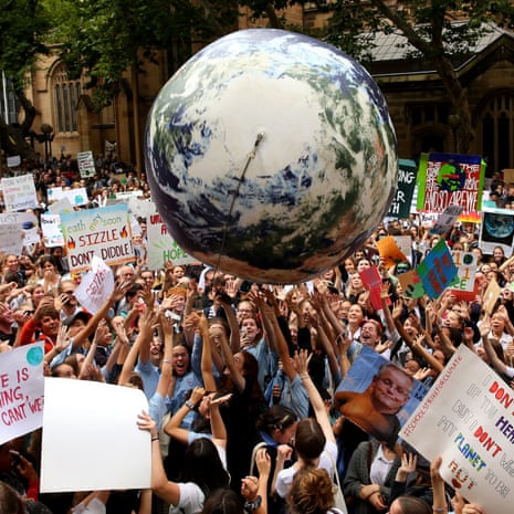 An inflatable planet earth is bounced around the crowd during a Climate Change Awareness rally at Sydney Town Hall.
