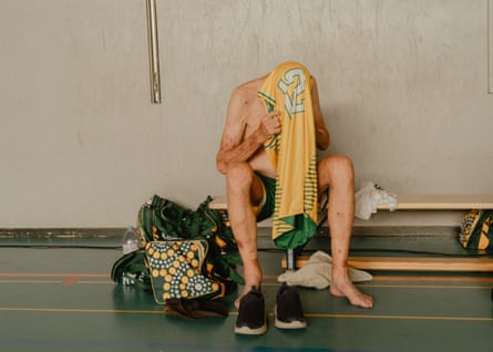A member of the Australia men’s over 80 basketball team takes off his jersey after a game