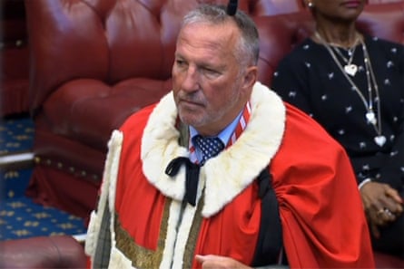 he is wearing a ceremonial red robe with white fur collar.