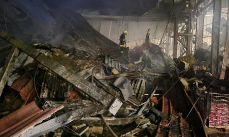 A firefighter picks his way through the rubble in the aftermath of a Russian missile strike on a warehouse in Odesa.