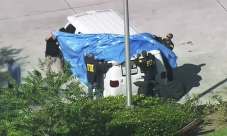 FBI agents cover a van parked in Plantation, Florida. Federal agents were seen removing a vehicle covered in political stickers from the location.