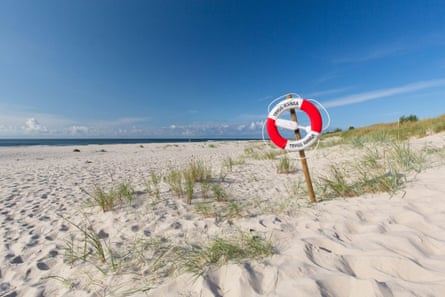 Fine sand, a life jacket ring, dunes and marram grass on a beach on a sunny day