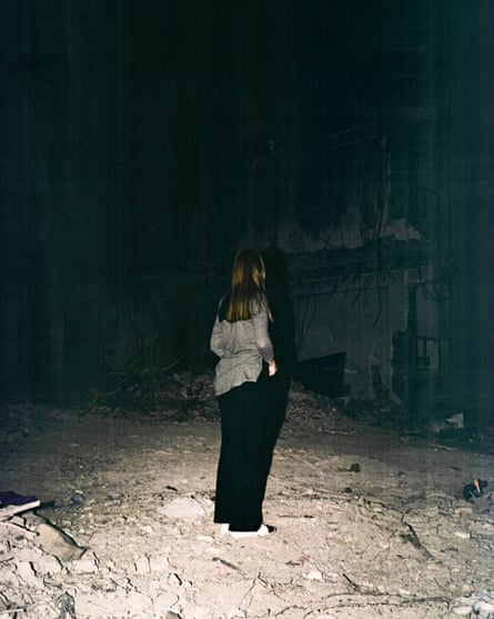 A 40-year-old woman, traumatised by Israeli missile strikes in June 2025, looks towards a ruined building opposite her home in Tehran