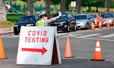 A traffic warden directs traffic as motorists arrive for Covid-19 tests at Dodger Stadium in Los Angeles, California on 8 October.