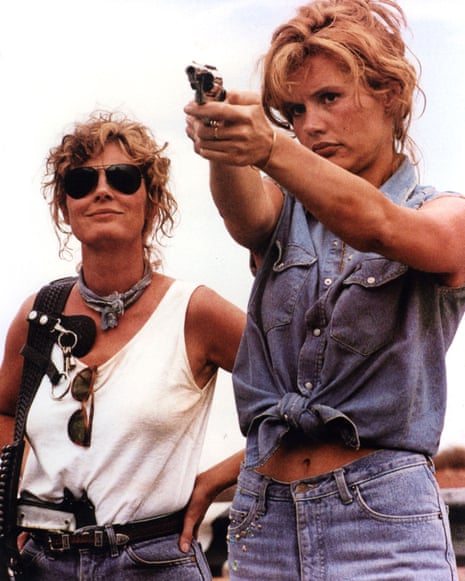 Thelma and Louise outdoors, with Geena Davis aiming a handgun as Susan Sarandon watches