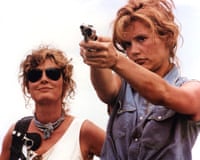 Thelma and Louise outdoors, with Geena Davis aiming a handgun as Susan Sarandon watches