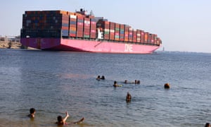 People play in the water as a ship sails on the Suez Canal in Ismailia Province, Egypt, last month.