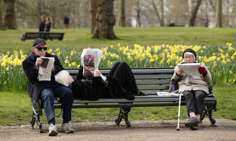 older people reading on park bench