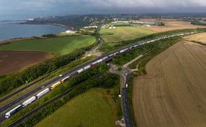 A queue of lorries on the A20 flanked by fields