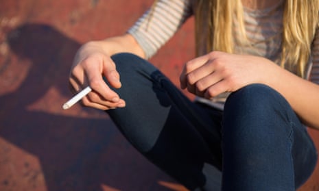 A teenage girl smoking a cigarette