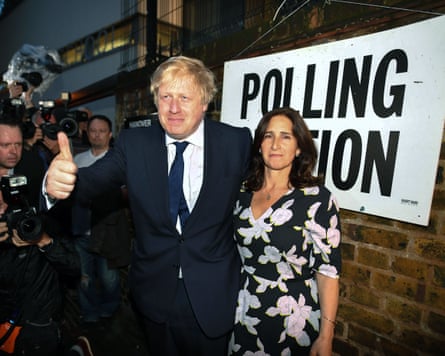Johnson gives a thumbs-up as he and Wheeler are photographed outside the polling station.