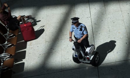 A mainland Chinese police officer patrols inside the departure hall of West Kowloon station in Hong Kong.