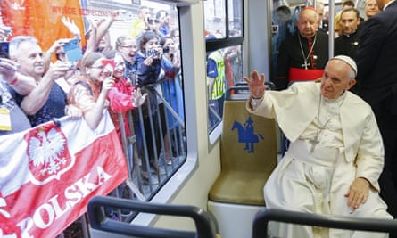 Pope Francis waves at crowds from the ‘Tram del Papa’.