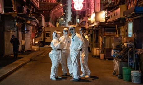 Government workers in protective gear on a Hong Kong street this year