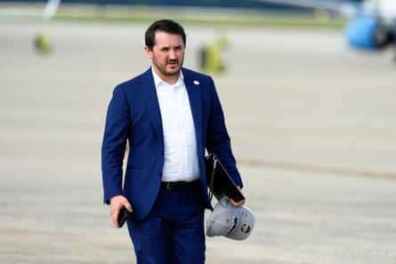 A man in a suit on a tarmac.
