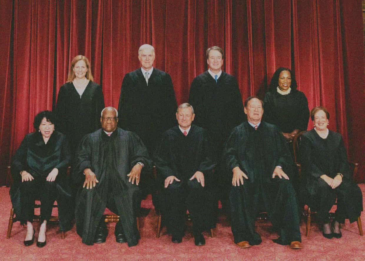 nine supreme court justices pose in their robes for a picture