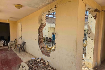 A damaged building with holes in the wall and a blown-out roof in the next room seen through the hole and a blown-out doorway.