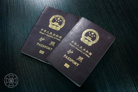 Picture of two Chinese passports lying on a desk bearing the words 'People's Republic of China' and 'Passport' in Chinese and English
