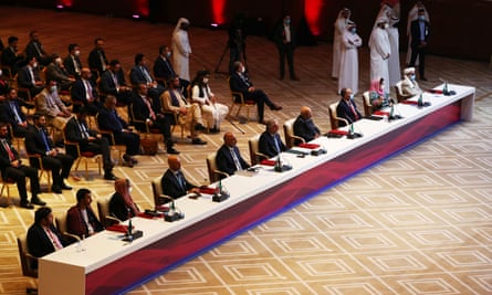 Delegates are seated before the talks at a hotel in Doha