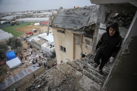 A young man walking amid the rubble of a house that was hit by Israeli bombardments in Rafah