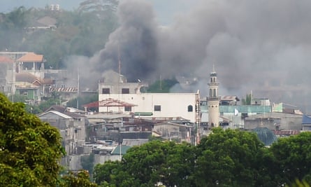 Smoke rises near a public market in Marawi.