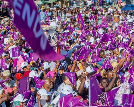 A crowd of people waving purple flags