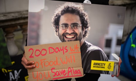 A man holds signs during a protest calling for the release of Alaa Abd El-Fattah, outside the UK Foreign Office in October 2022.