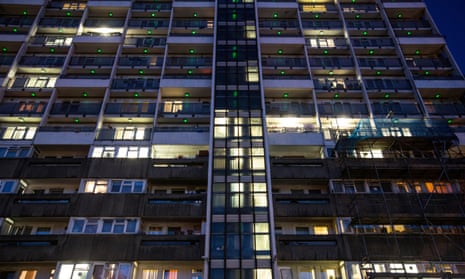 Lights come on at twilight in a block of social housing flats