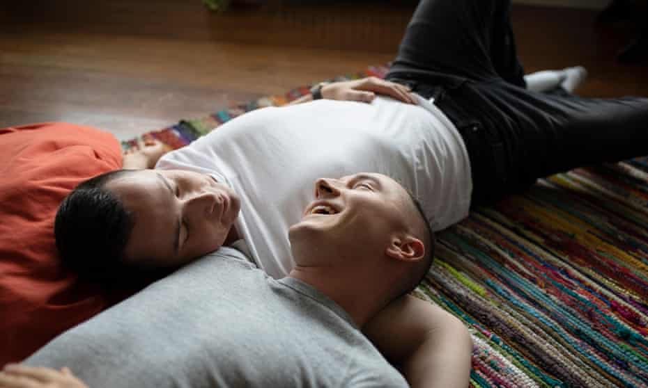Affectionate male couple cuddling on rug