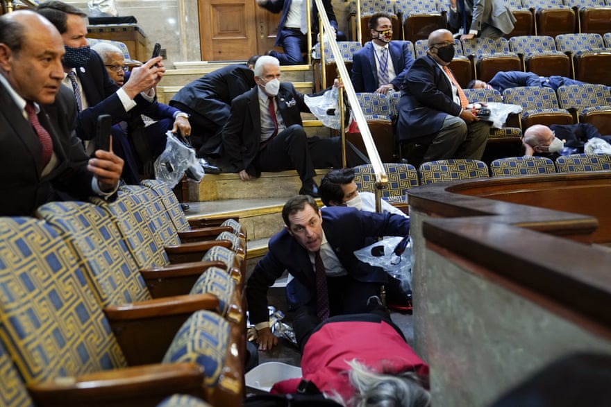 People shelter in the House gallery as pro-Trump mob try to break into the House Chamber at the US Capitol on Wednesday.