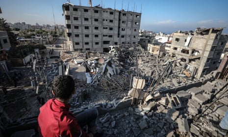 A Palestinian boy inspects the rubble of the Al-Aqsa TV's building after it was targeted by Israeli airstrikes in Gaza
