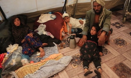 People sit on the floor among their possessions