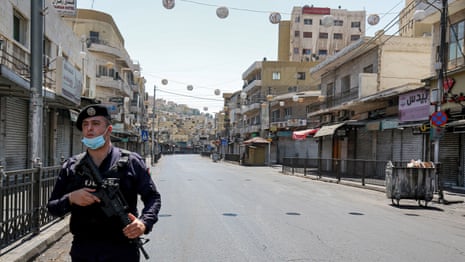 A policeman stands on guard while enforcing a curfew due to the Covid-19 coronavirus pandemic along a street in Jordan’s capital Amman on 28 August, 2020.
