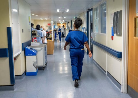 NHS staff walking in a hospital corridor qhxidiqxkiqtdinv