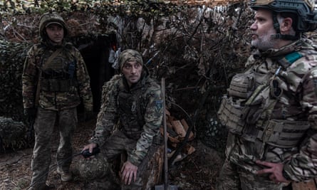 Ukrainian soldiers rest next to a shelter in their fighting position on the frontline in Donetsk region