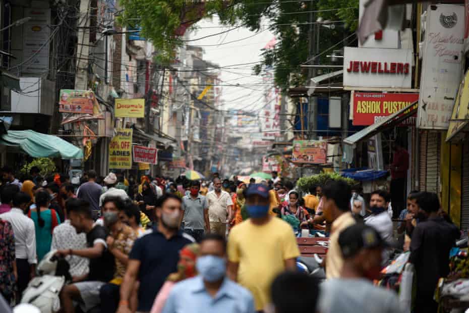 People flout social distancing norms as they throng a market for shopping, near Post Office, on June 13, 2021 in Gurugram, India. 